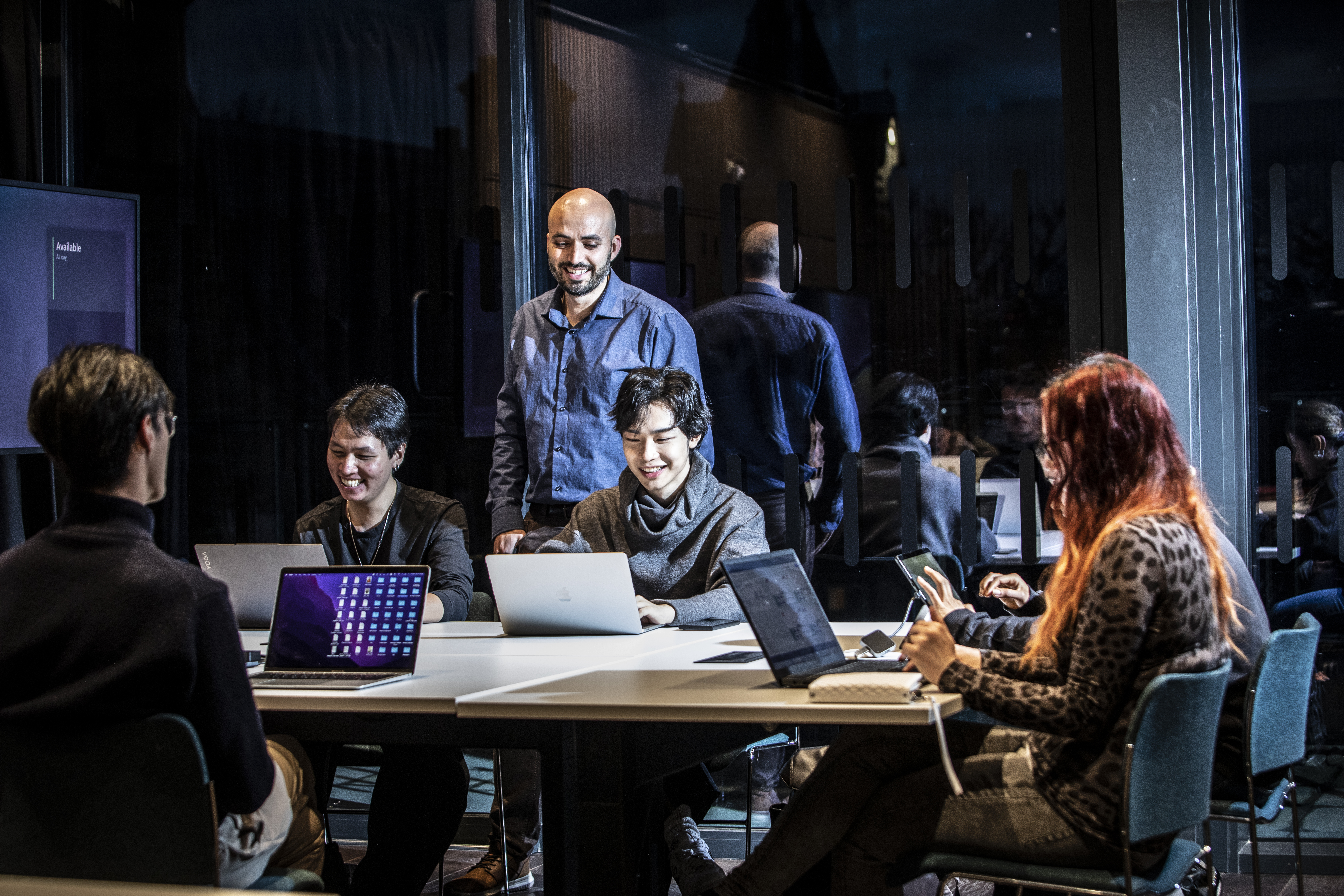 Team collaborating around a laptop